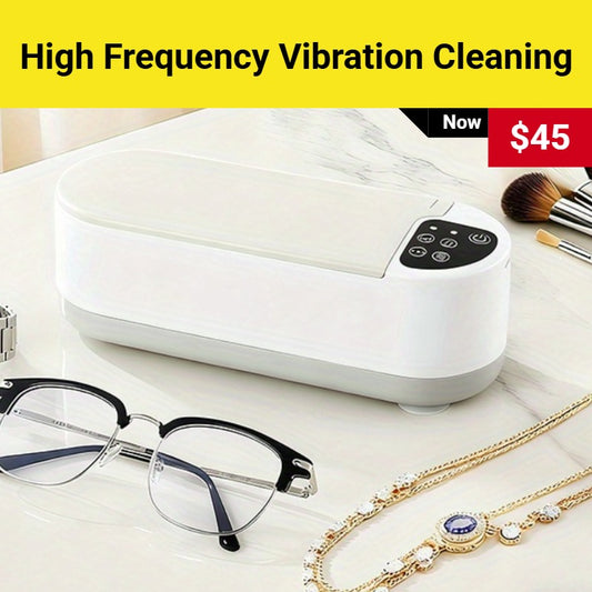 White cleaning device with high frequency vibration cleaning feature, displayed with glasses and jewelry on a white surface.