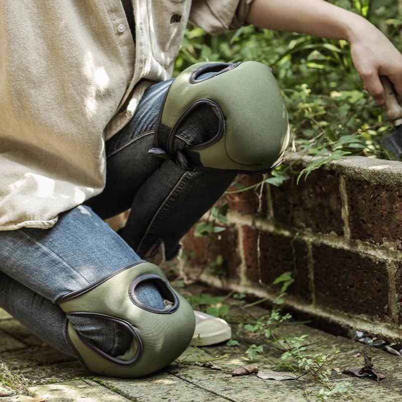 Person wearing green knee pads on a brick path with grass in the background