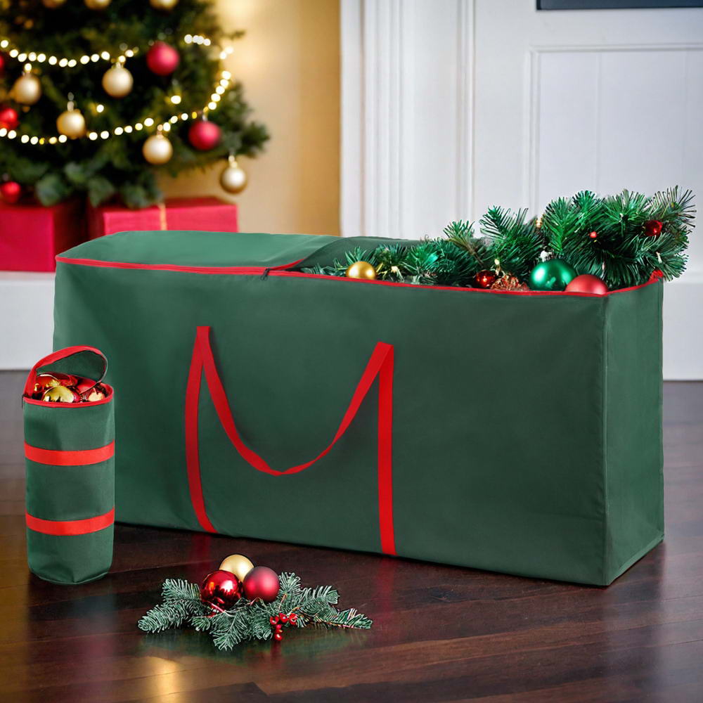Green storage bag with red straps filled with Christmas decorations on a wooden floor.
