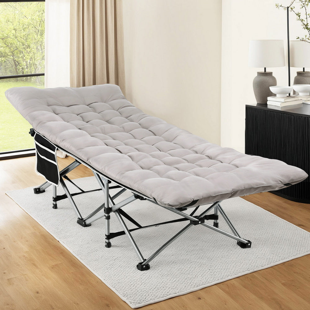 Gray folding bed in a room with a desk and lamp