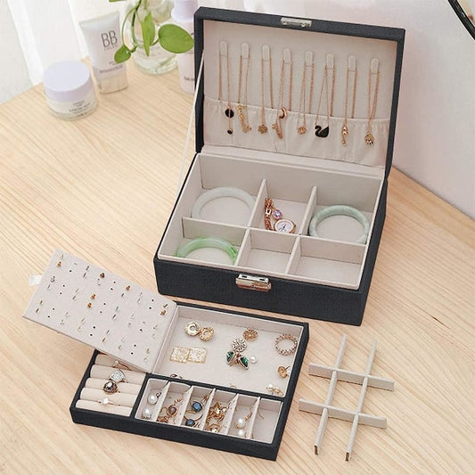 Open jewelry box with various jewelry items on a wooden surface