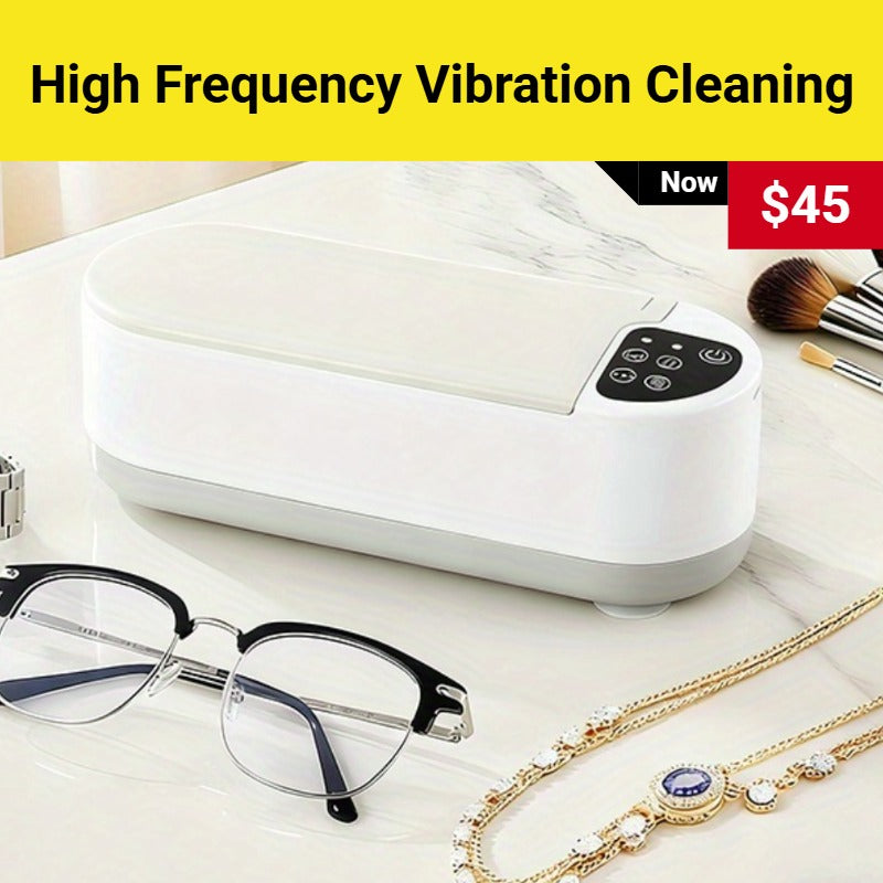 White cleaning device with high frequency vibration cleaning feature, displayed with glasses and jewelry on a white surface.