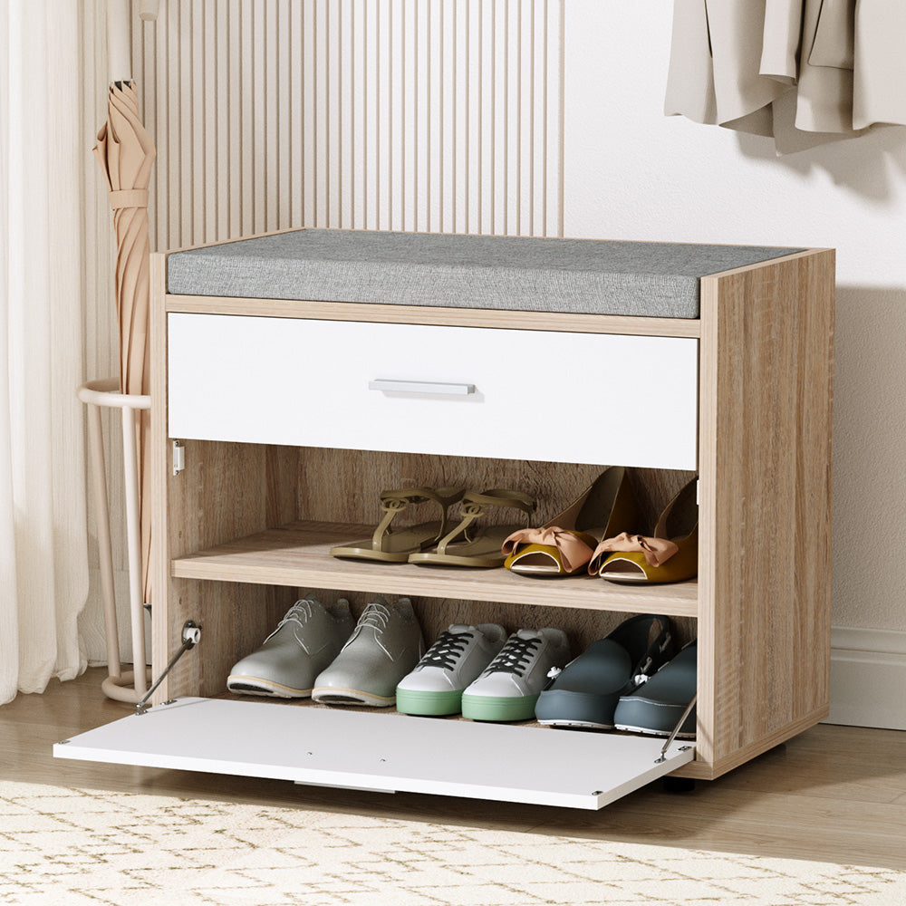 Wooden shoe cabinet with open drawer showing shoes inside, against a neutral background.